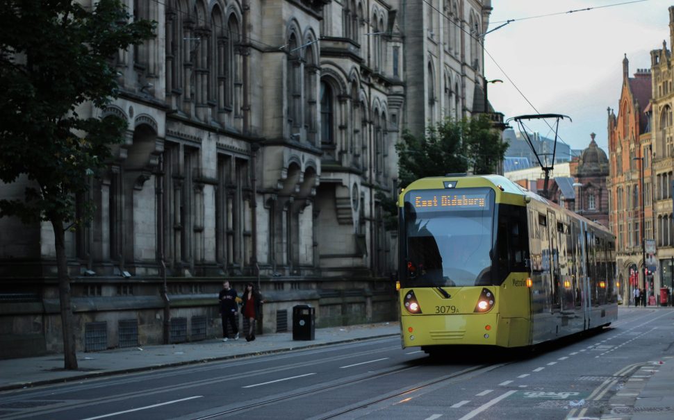 A tram rides through Manchester City Centre