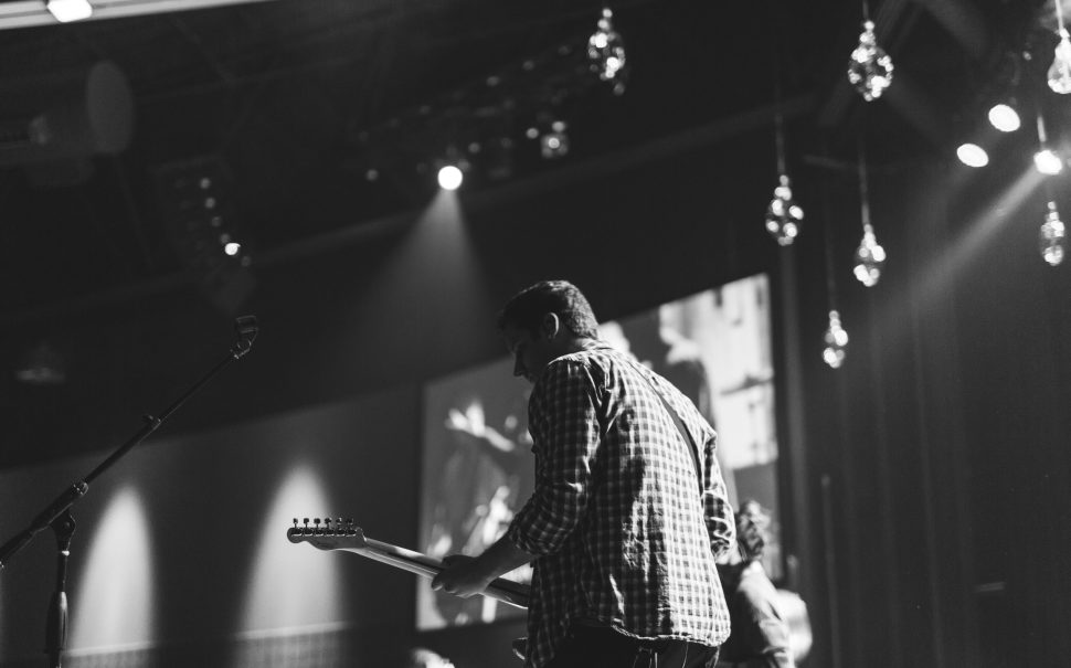 A man plays lectric guitar on stage