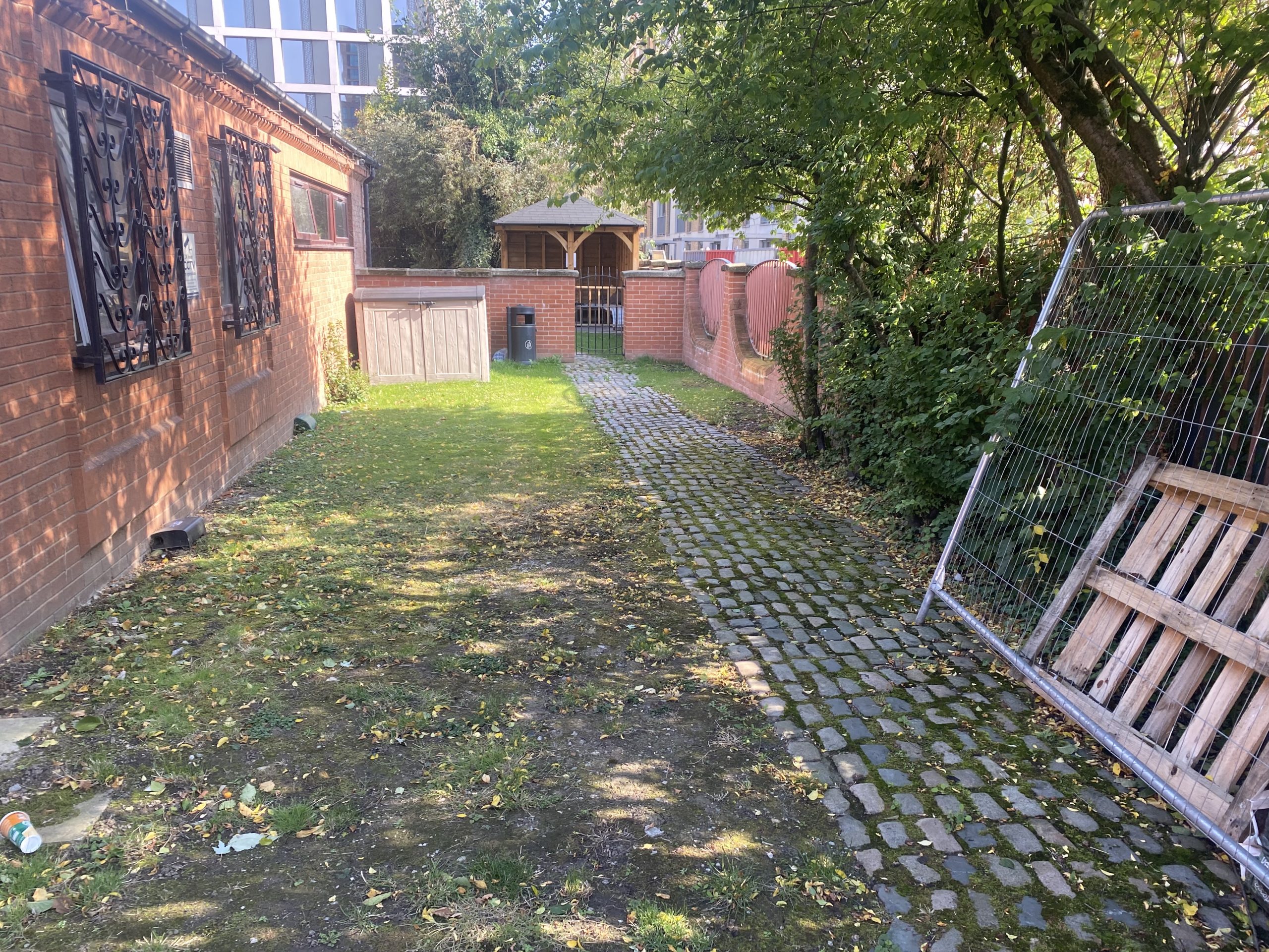 Cobblestone path and green space enclosed