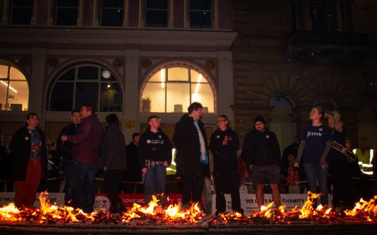 Firewalkers behind a lane of lit coals